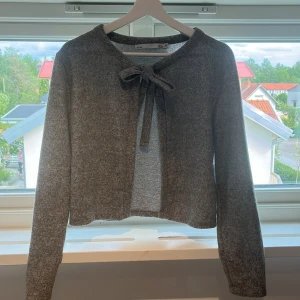 Grå kofta med knyt från 157 - Mysig grå kofta från 157 i mjukt material. Den har långa ärmar och knytband vid halsen nästan aldrig andvänd 