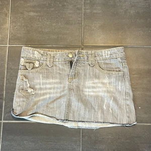 Grå jeanskjol med slitna detaljer - Säljer denna så coola unika jeans kjolen. Köpt second hand för 500 kr. 