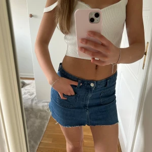 Blå jeanskjol från Paris Atelier - Säljer en skitsnygg blå jeanskjol från Paris Atelier & other stories. Kjolen är kort med rå, fransig kant nertill och har stora fickor både fram och bak. Klassisk denim med bälteshällor och knappstängning.