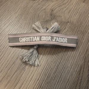 Christian Dior J'Adior armband - Säljer ett armband från Christian Dior. Armbandet har justerbara tofsar. Hör av er vid frågor. 