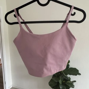 Ljusrosa linnetopp från H&M Sport - Supersöt ljusrosa linnetopp från H&M Sport med smala, justerbara axelband. Croppad och sitter som en smäck.