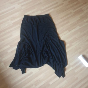 Svart långkjol från Cellbes - Svart långkjol från Cellbes med asymmetrisk och flowy nederkant. Kjolen har resår i midjan för extra komfort och är tillverkad i ett mjukt tyg som faller snyggt. Perfekt för dig som gillar en enkel men cool stil.