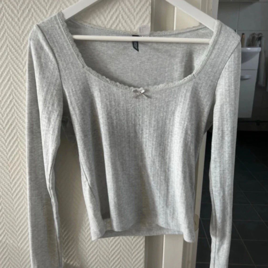 Ljusgrå pointelle topp med spets och rosett