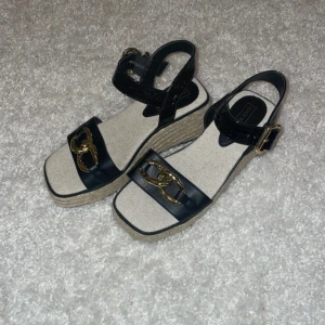 Svarta platåsandaler River Island - Köptes på Sellpy. Nypris 27£ stl 34,5/35 (sulans längd: 22,5cm) Klack: 6cm, sula/platå: 3cm I mycket fint skick! ser inte ut som de ens har använts.