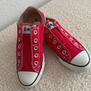 Nya. Röda Converse All Star sneakers - Klassiska röda Converse All Star sneakers i canvas med vit gummitå och sula. Låga med vita kontrastsömmar och metallöljetter, modellen är så, utan snören. Perfekta för en avslappnad och cool stil.