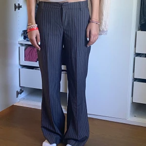 Grå randiga kostymbyxor med bootcut - Snygga grå vitrandiga kostymbyxor🩶🤍Användt fåtal gånger. Jag är 1,65 på bilden💕