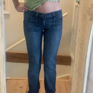 Blå lågmidjade coola jeans - Säljer mina skit snygga mörkblå jeans från rock & republic. Jeansen är lågmidjade och är lite utsvängda men det syns inte då dom är för långa för mig. Jag är 1,63. Storlek 26/XS