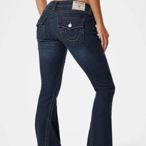 Mörkblå low bootcut jeans True Religion - Snygga mörkblå jeans från True Religion med bootcut passform. lågmidjade. Perfekta för dig som gillar en snygg och cool look. Kan matcha med precis allt ifrån mjukiskläder, stickat eller fest topp. W23 men passar mer mot w26 lite små för mig därför jag säljer 