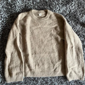 Beige stickad tröja Arket - Mysig beige stickad tröja i storlek XS med rund halsringning och ribbade muddar. Perfekt för lager-på-lager och chill dagar. Enkel och stilren design som funkar till det mesta. En tröja i Alpacka från Arket💕