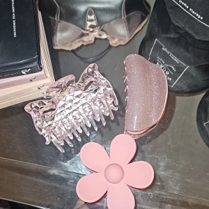Rosa hårklämmor och blomma - Två snygga rosa hårklämmor, en med glittrig finish och en med coolt mönster, samt en söt blomformad accessoar i ljusrosa. Perfekt för att piffa upp frisyren med en gullig touch.
