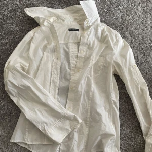 Vit skjorta från Marc O'Polo - Klassisk vit skjorta från Marc O'Polo i bomull. Skjortan har lång ärm, bröstficka och knappar framtill. Snygg, enkel och passar perfekt till jeans eller kjol. Rak passform och stilren design. Använd ett fåtal gånger och är i storlek 38.