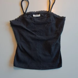 Svart ribbad linnetopp från Kappahl💫 - Svart ribbad linnetopp från Kappahl med tunna axelband. Toppen har en croppad passform. Materialet är mjukt och stretchigt för extra komfort. 🦋 Skicka meddelande vid frågor💕