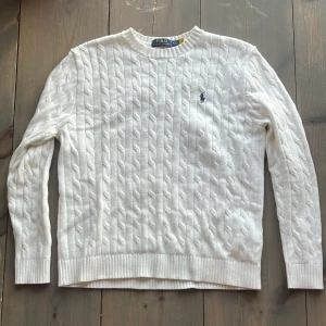 Kabelstickad Polo Ralph Lauren - Vit kabelstickad tröja från Polo Ralph Lauren med klassisk och klockren stil. Helt oanvänd skick 10/10, snabb affär = bra pris. Byten fungerar.