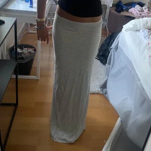 Ljusgrå långkjol i bomull - Superskön och enkel ljusgrå långkjol med rak passform. Kjolen är i mjukt bomullstyg och har en clean look utan detaljer. 