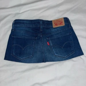 Jeanskjol minikjol blå denim med Levi’s fickor - Jättesnygg mörkblå jeanskjol med snygga detaljer på fickorna🤩 har sytt om från ett par Levis jeans. Inga tecken på användning. Midja: 33cm bred längd: 24cm. Skriv gärna om frågor och skicka prisförslag!!! Kolla även på mina andra kjolar om du är intresserad🥰