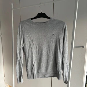 Grå bomullströja från Morris Stockholm - Snygg grå långärmad tröja från Morris Stockholm i 100% pima bomull. Klassisk rund halsringning och diskret broderad logga på bröstet. 