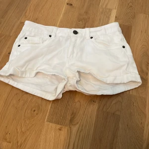 Vita shorts från WA i bomull - Snygga vita shorts från WA i klassisk femficksmodell. Gjorda i mjuk bomull med midwaist passform och justerbar midja på insidan. Perfekta för varma sommardagar och enkla att matcha med allt. Stilsäkra och bekväma shorts för dig som gillar en clean look.