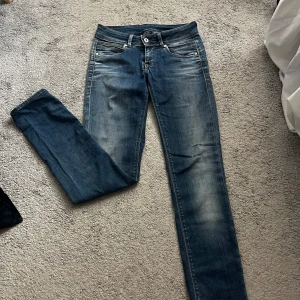 Blå skinny jeans från Pepe Jeans - Snygga blå skinny jeans från Pepe Jeans med klassisk femficksdesign och coola detaljer på bakfickorna. Jeansen har en mellanblå tvätt med slitningar och kontrastsömmar. Perfekta för dig som gillar en smal passform och stilren look. Jeansen har en liten fläck på sig (se bild).