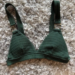 Grön ribbad bikinitopp - Supersnygg grön bikinitopp med breda axelband och ribbad struktur. Triangelmodell med detaljer i form av mönstrade ringar🫶🏼