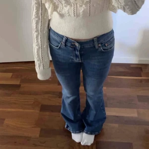 Blå bootcut jeans med utsvängda ben - Snygga blå jeans med bootcut-modell och utsvängda ben. Klassisk femficksdesign och normal midja. Jeansen har en lätt tvättad look och är perfekta för dig som gillar en retrostil.