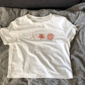 Vit t-shirt  - Vit t-shirt i bomull med tryck framtill. Hel vit som ifram på ryggen. Jag ville den skulle va overzize men den va väldigt liten i storleken så slaffa i L men den sitter som S