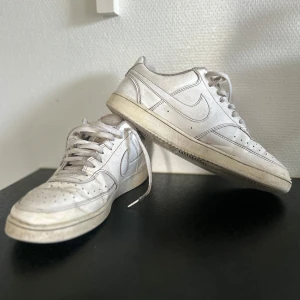 Nike Sneaker Court Vision Låg - Nike Court vision låg sneakers i helvitt skinn med perforerad tå och snörning. Snygg och tidlös modell med låg profil och rund tå. Perfekta för dig som gillar streetstyle och vill ha en ikonisk sneaker i garderoben. Accepterar rimlig motbud för snabb affär! 