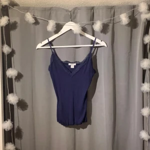 Linnetopp - Supersöt mörkblå linnetopp från Amisu med smala axelband och v-ringning dekorerad med spets. Aldrig använd! 💙