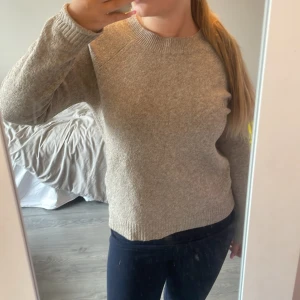 Beige stickad tröja - Stickad tröja ifrån veromoda kan har någon tråd som sticker ut kan ha någon till och den är knottrig, tröjan har även som en buckla så går in i sömmen annars ser den bra ut 