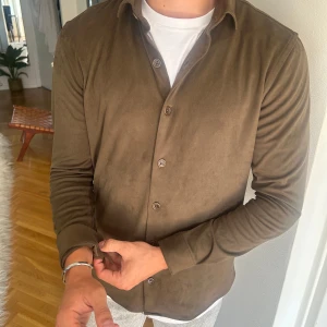 Olivgrön skjorta i mocka från Ciszere - Snygg olivgrön skjorta från Ciszere i  mocka. Använd fåtal gånger och är i mycket bra skick.