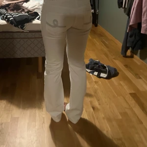 Vita lågmidjade jeans vintage - Snygga vita lågmidjade jeans. Byxorna har fina silverfärgade broderade detaljer på bakfickorna. Fråga om ni undrar något 💕