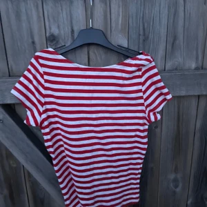Randig röd och vit topp från Monki - Säljer en randig topp från Monki. Storlek är M men den har krympt i tvätten så passar bättre på storlek S. T-shirten har röda och vita horisontella ränder, rund halsringning och korta ärmar. Perfekt för dig som gillar cool Pinterest girl look 