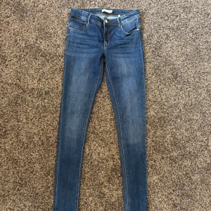 Blå skinny jeans från Name It - Snygga blå skinny jeans från Name It i storlek 164. Klassisk femficksmodell med dragkedja och knapp framtill. Jeansen har en smal passform och är tillverkade i stretchigt denim för extra komfort. Perfekta för dig som gillar en tajt look. Köpte i helgen i syfte till att göra de till jeans shorts men tänkte att jag kunde sälja dem istället. Jeansen är i helt nytt skick, och har aldrig används men saknar tyvärr prislapp. 