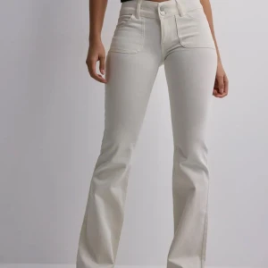 Vita bootcut jeans med fickdetaljer - Säljer mina slutsålda vita bootcut jeans från Nelly då dem tyvärr inte passar mig längre! Endast använda 1 gång🫶🏻