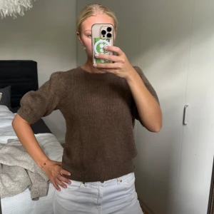 Brun trekvartsärmad stickad tröja - Jättefin oanvänd brun stickad t-shirt med jättefina volanger/detaljer. Den har jättefin färg som passar väldigt bra med vitt! Den är ifrån Vero Moda i storlek XS men jag tycker den känns som S. 