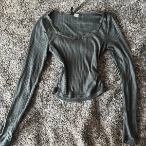Grå ribbad topp med spets från H&M Divided - Använd några gånger, lite nopprig i armhålorna men annars i superfint skick. Supersnygg grå ribbad långärmad topp från H&M Divided i storlek XS. 