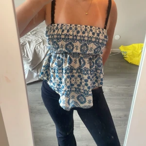 Vit topp med blå detaljer - En vit topp med fina blå detaljer som ger lite Grekland vibes säljer dennna då den aldrig kommit till användning så den är i ett nytt skick 