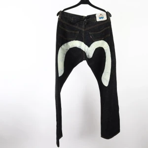 Vintage Evisu Likande Märkesjeans - Unika svarta jeans från Justin med coolt vitt tryck på baksidan. Klassisk femficksmodell i 100% bomull med kontrastsömmar och rak passform. 32/32 och bra skick, fråga om mer bilder mått osv (: