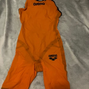 Tävlingsbaddräkt  - Tävlingsbaddräkt från arena i orange. Storlek 32 i uk men jag tycker den är tajtare. Använd en gång. Pris går att diskutera!
