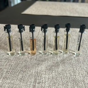 Set med 7 parfymprover i glasflaskor - Säljer ett set med sju parfymprover i små genomskinliga glasflaskor med svarta skruvkorkar. Doftnamn som Freshotic, Supreme Amore, Orange Blossom, Vanilla Sass, Absolu Vanilla, Boosy Peach och Coco Heaven. Perfekt för dig som vill testa olika dofter.
