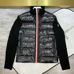 Svart dunväst från Moncler - Snygg svart dunväst från Moncler med glansig finish och quiltad framsida. Västen har en rödvit randig dragkedja och höga fickor med dragkedja. Ärmarna är stickade i svart och ger en cool kontrast till det blanka materialet. nfc scan finns