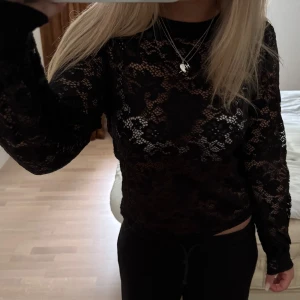 Svart spetsblus från ONLY - Säljer en svart långärmad blus från ONLY i genombruten spets med blommigt mönster. 👍👍💞