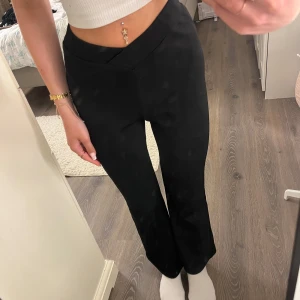 Svarta bootcut byxor med omlottmidja - Svarta bootcut byxor med omlottmidja från SHEIN i storlek petite XS så passar tjejer som är lite kortare :)