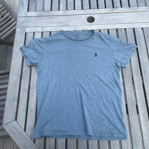 Blå t-shirt från Polo Ralph Lauren - Snygg blå t-shirt från RL som är tilllverkad i mjuk bomull som känns skön mot huden. Perfekt för en chill och stilren look nu på sommaren. Tröjan har inga tecken på användning. Passar någon som är runt 170cm. Kontakta vid frågor!