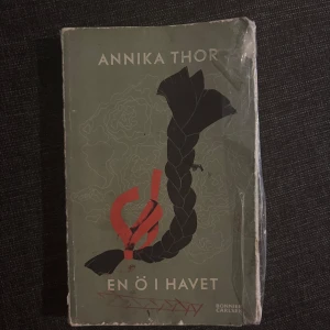 En ö i havet - En ö i havet av Annika Thor är en bok med ett spännande omslag som lockar till läsning. Perfekt för unga som gillar berättelser med djup och känsla. Boken har ett slitet men charmigt utseende, vilket ger den extra karaktär.