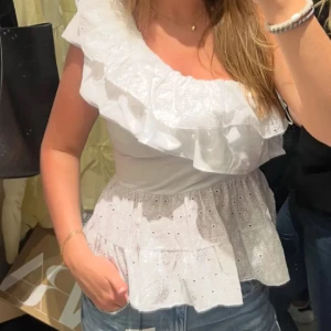 Vit populär volangtopp  - Supersöt vit oneshoulder topp med volanger!! Så snygg och passar perfekt nu i sommar💗Nytt skick