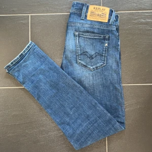 Replay Jondrill skinny jeans blå - Snygga Replay Jondrill skinny jeans i klassisk blå tvätt. Jeansen har fem fickor, tydliga slitningar och en smal passform. Märkespatch bak i midjan och cool detalj på bakfickan. Perfekta för dig som gillar en tajt och modern look.