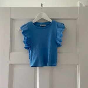 Säljer en superfin ljusblå croppad topp med volang från Zara - Jättesnyggt linne/blus ifrån märket Zara i storlek S, den är super skön/sval med fina detaljer/volanger på ärmarna och den är perfekt nu till våren&sommaren, inför alla speciella tillställningar som studenten, examen, midsommar, olika middagar eller bara till vardagen🌸 Den är i mycket bra skick, bara använd fåtal gånger, är i väldigt bra material/kvalitet, är enkel att styla och har väldigt fin passform⭐️Skriv om funderingar, lämna gärna omdöme om köpt och priset kan diskuteras😊