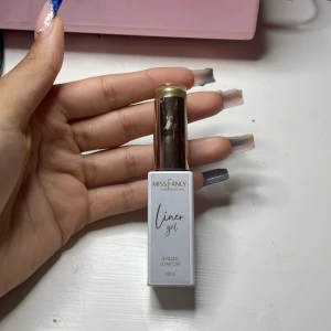 Miss Fancy Liner Gel Guld - Miss Fancy Professional Liner Gel i en snygg metallisk guldig nyans. Perfekt för att skapa detaljerade och kreativa eyeliner-looks. Kommer i en vit flaska med guldfärgat lock och smal pensel för precision. UV/LED soak off, 10 ml.