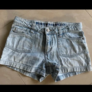 Ljusblå lågmidjade shorts  - Snygga ljusblå lågmidjade jeansshorts från Mossimo Supply Co med klassisk femficksdesign, bälteshällor och dekorativa sömmar på bakfickorna. 