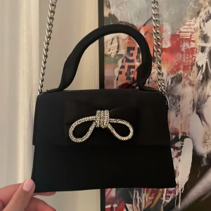 Svart handväska med strassrosett - Fin svart väska med glittrig rosett ❤️